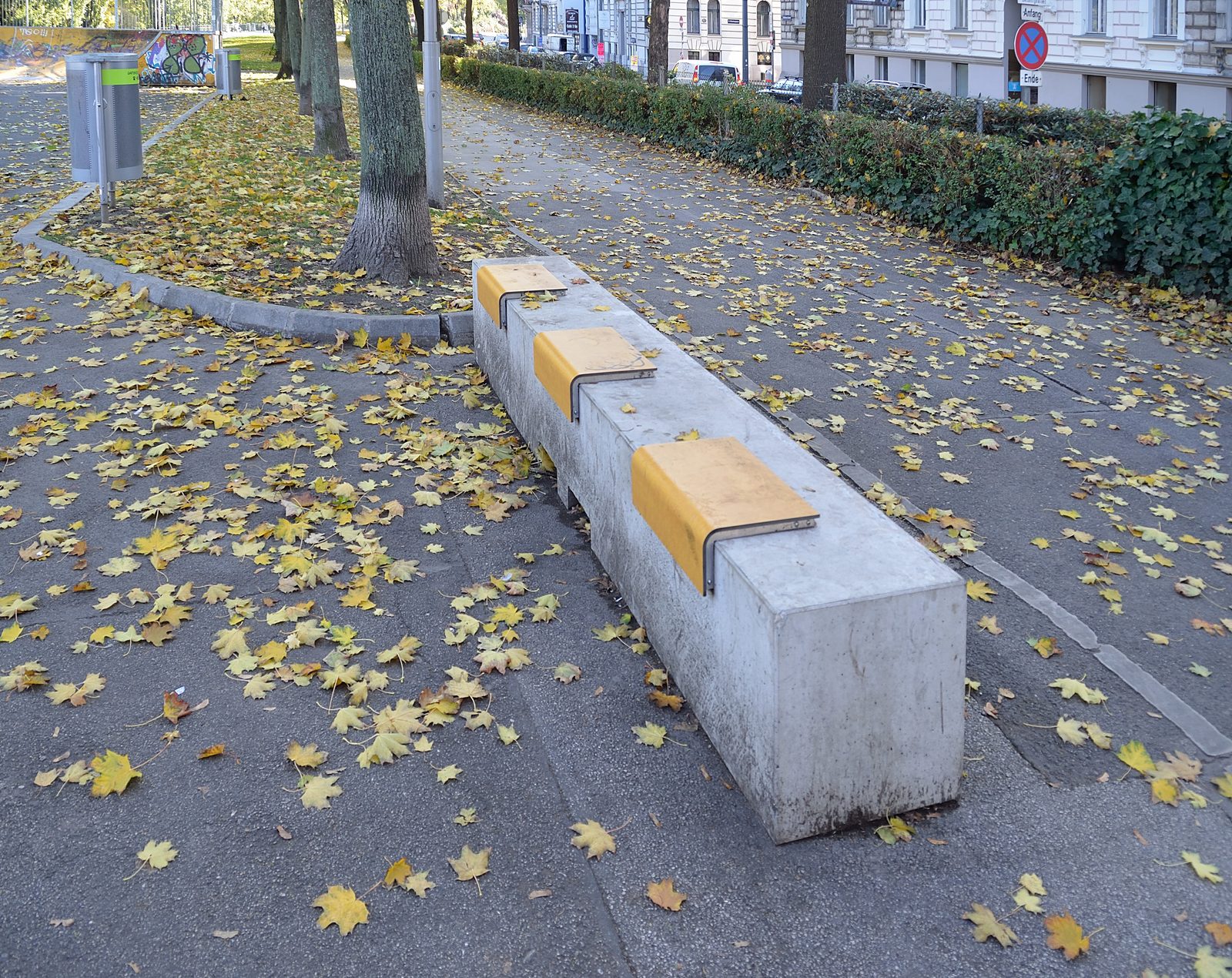 Long concrete public bench divided into individual seats by raised dividers