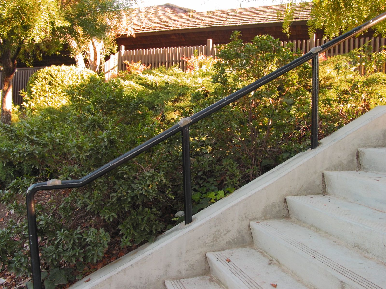 A stair handrail fitted with metal knobs along its length to prevent grinding